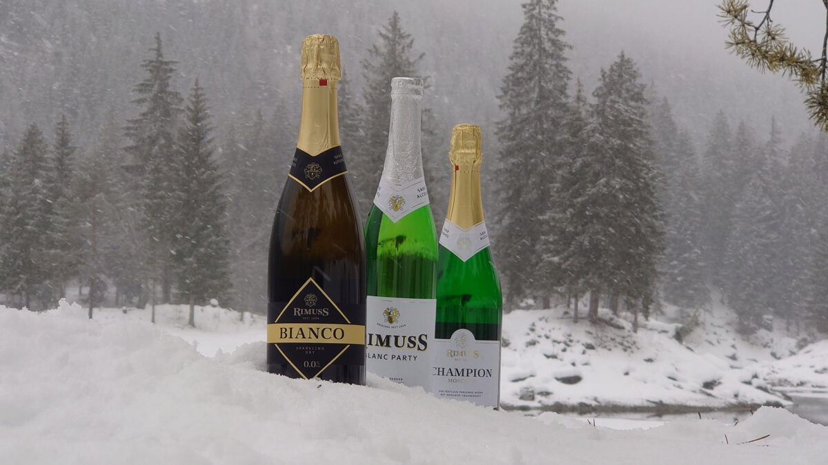 Drei Flaschen Rimuss um verschneiten Winterwunderland. Alles für einen schönen Winter Apero