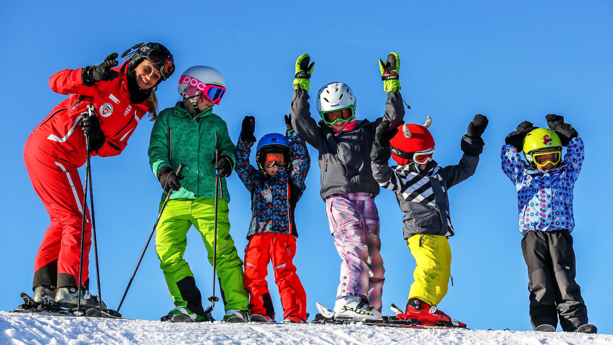 Meherer Kinder auf Skis und eine Skilehrerin auf einem verschneiten Hügeln freuen sich beim Kindergeburtstag in Grüsch Danusa